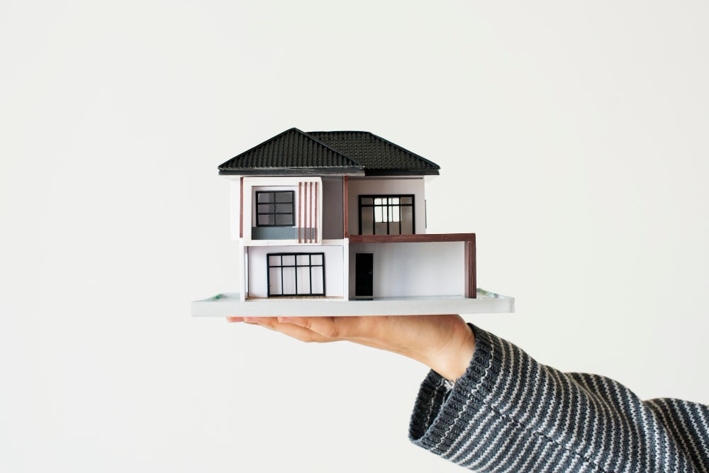 Person holding a model house