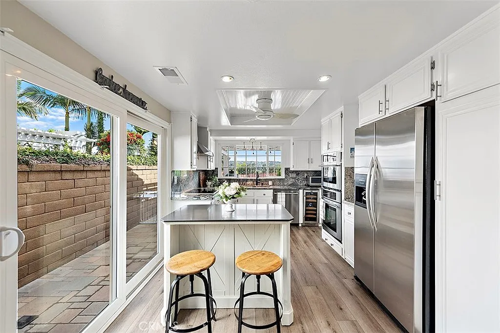 Kitchen with white cabinets island and outdoor patio view