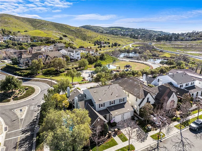 Aerial view of California real estate houses with green hills and water