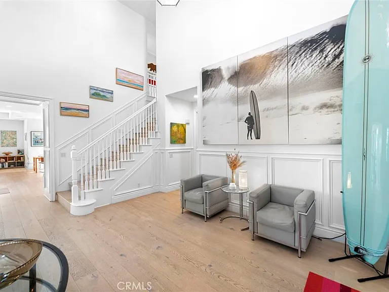Hallway with surfboard chairs artwork and staircase
