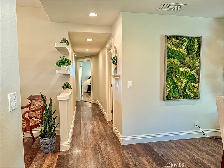 Hallway with wooden floors plants and artwork