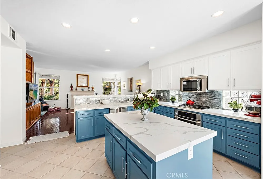 Kitchen with blue cabinets island and living area view