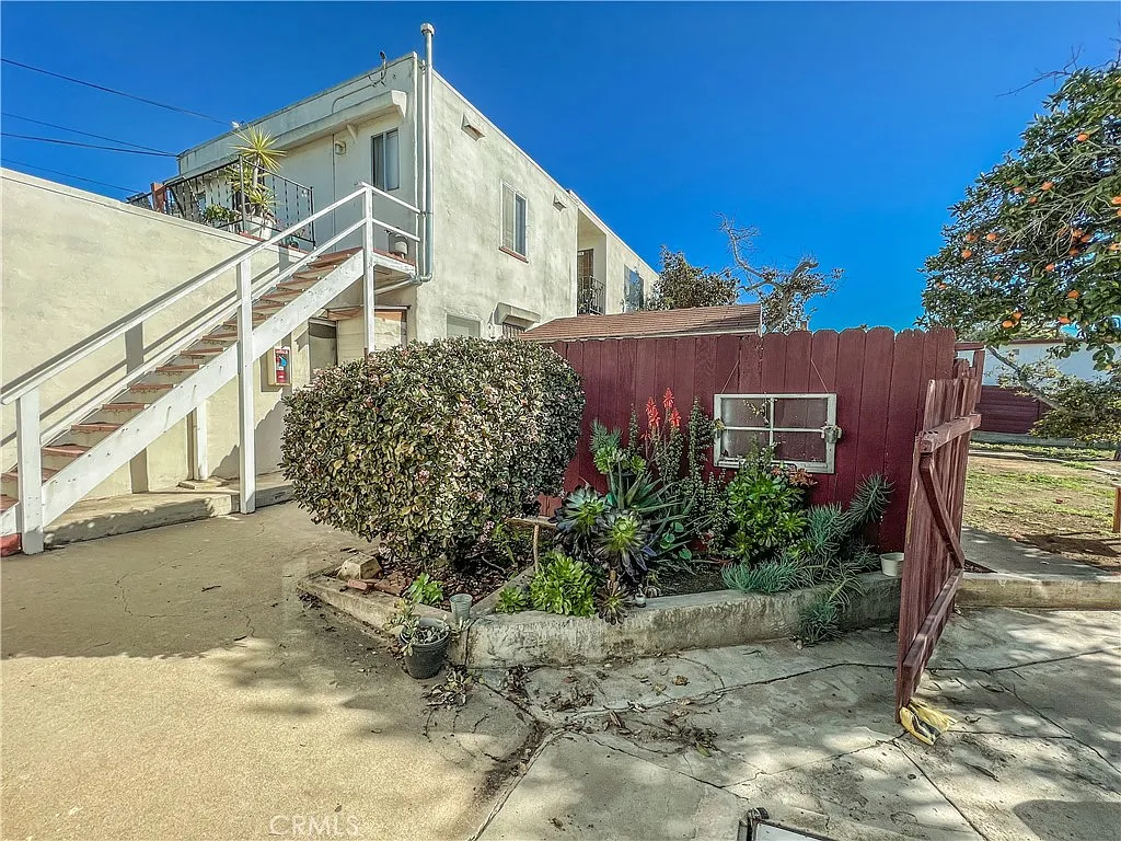 Outdoor area with paved path red fence and building entrance