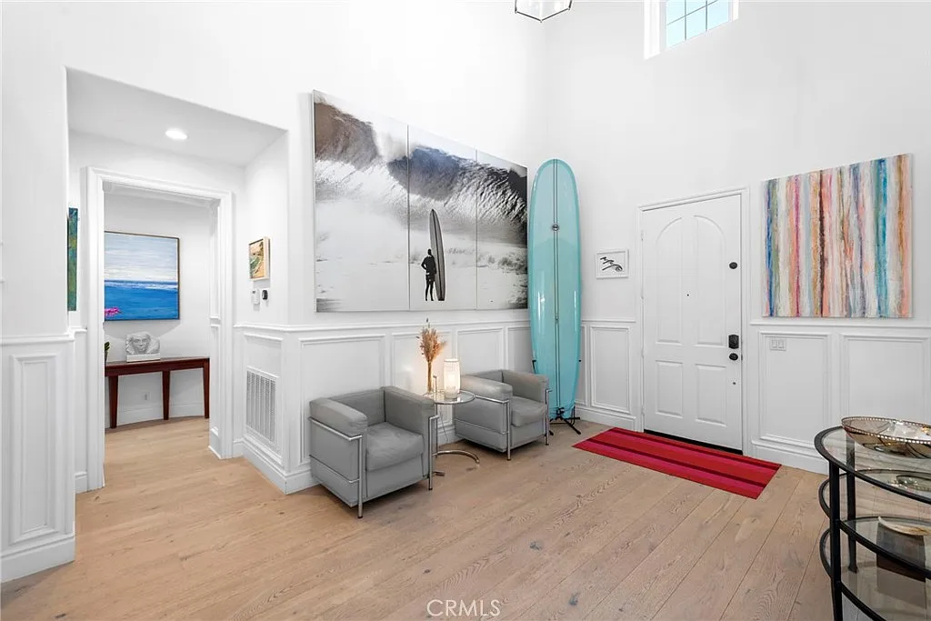 Entryway with chairs surfboard artwork and table