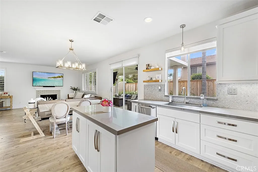 Kitchen with island and living room with window and TV