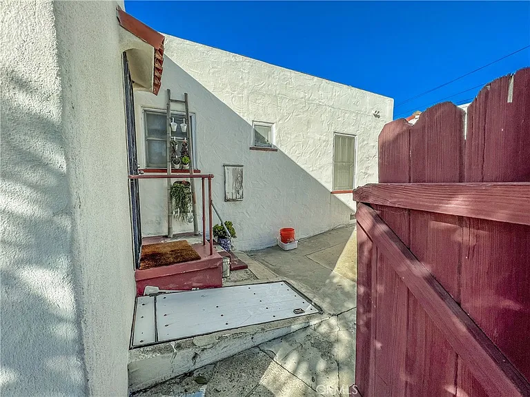 Outdoor area with paved path red fence and building entrance