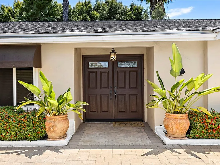 Front of California real estate house with double doors plants and flowers