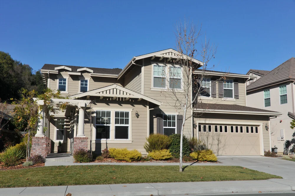 Two story California real estate house with porch driveway and landscaped yard