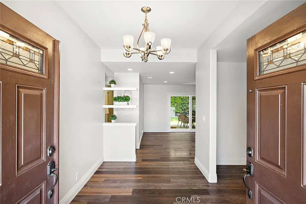 Interior view of California real estate house with double doors chandelier and wooden floors