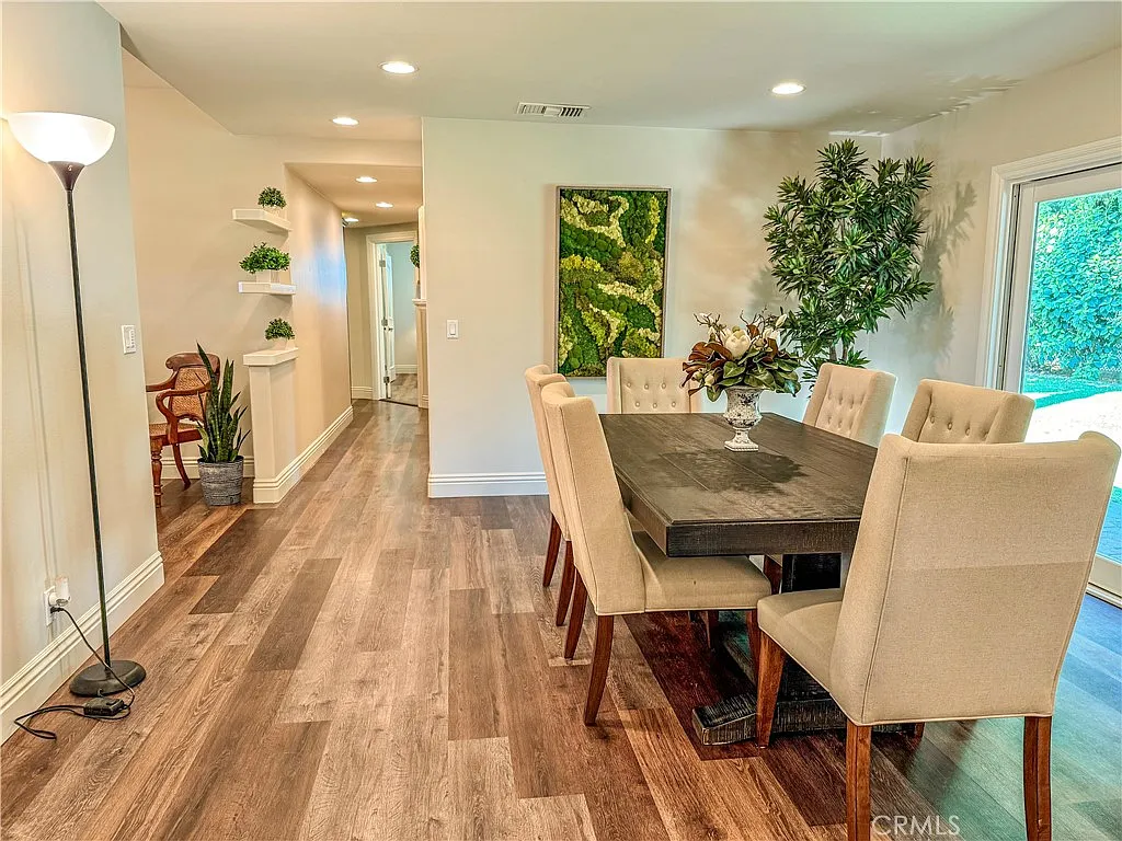 Dining area with wooden table chairs and plant centerpiece