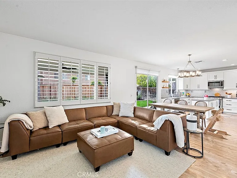 Living room with brown sofa coffee table and open kitchen