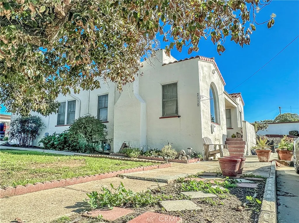 Single story California real estate house with red tile roof and green grass