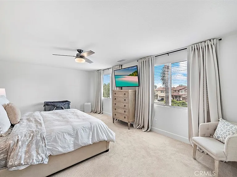 Bedroom with bed TV dresser and armchair