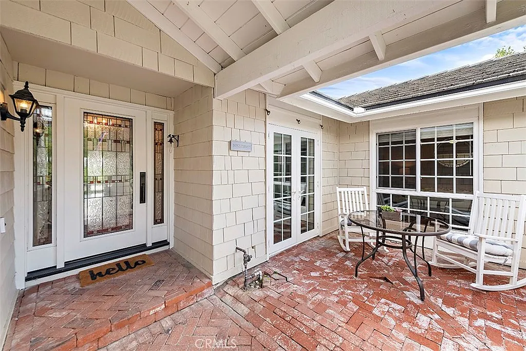 Porch of California real estate house with glass door rocking chairs and table