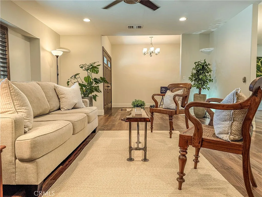Living room with beige sofa chairs coffee table and plants
