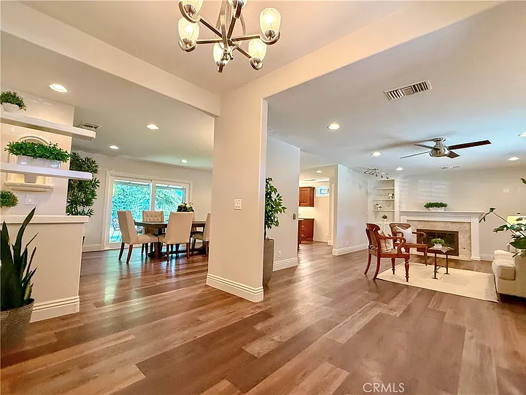 Living room with hardwood floors dining area fireplace and plants