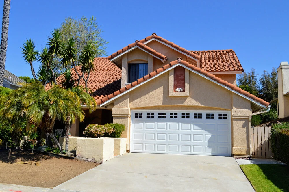 California real estate house with red tile roof garage and palm trees