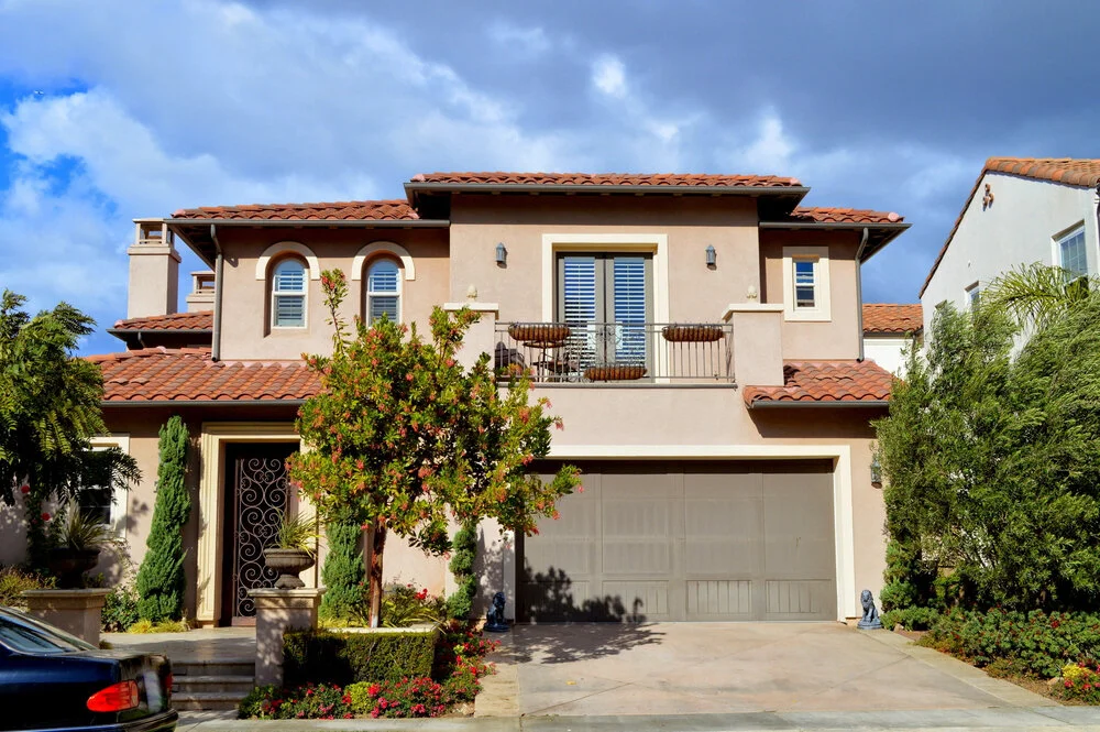 Two story California real estate house with stucco exterior garage balcony and yard