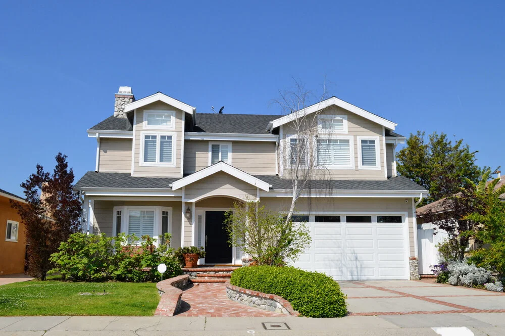 Two story California real estate house with siding shutters garage and garden