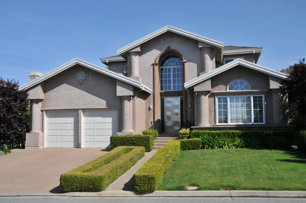 Two story California real estate house with light exterior porch large windows and garage