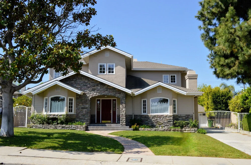 Luxury two story California real estate house with stone facade red door and law