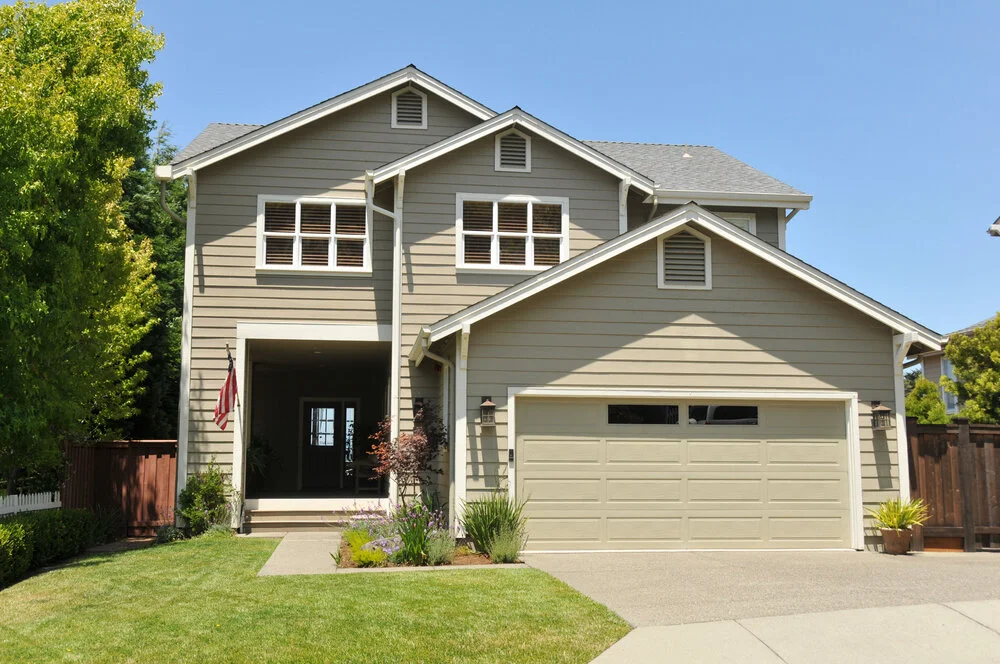 Two story California real estate house with yellow exterior shutters driveway and yard
